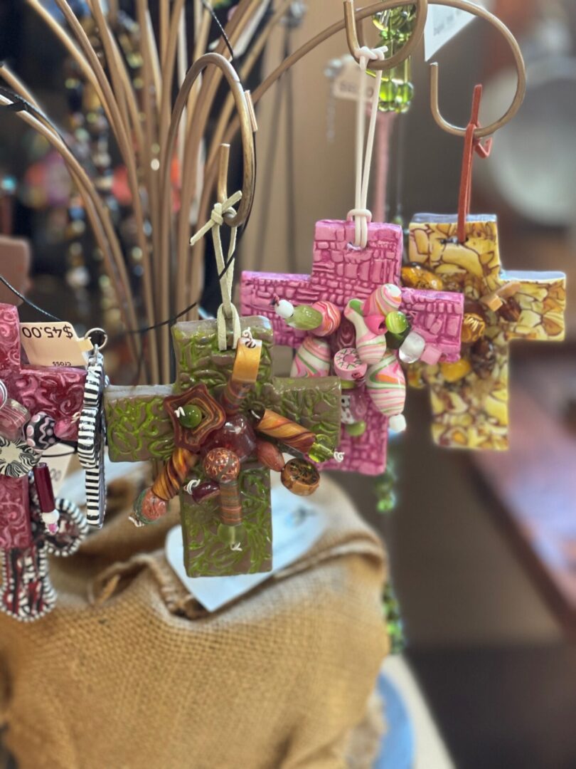 A group of cross ornaments hanging from a tree.