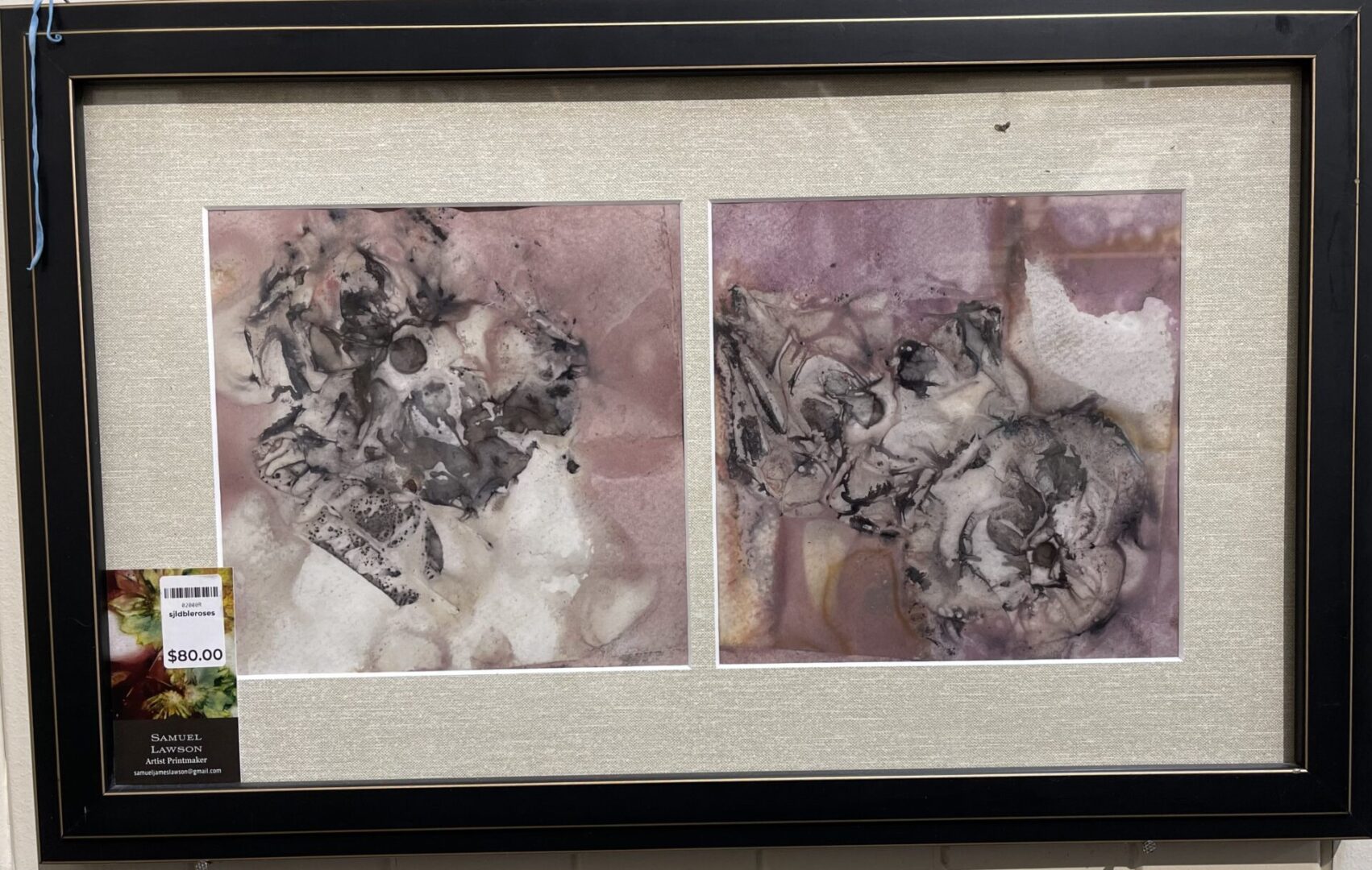 Two framed pieces of art on display in a store.