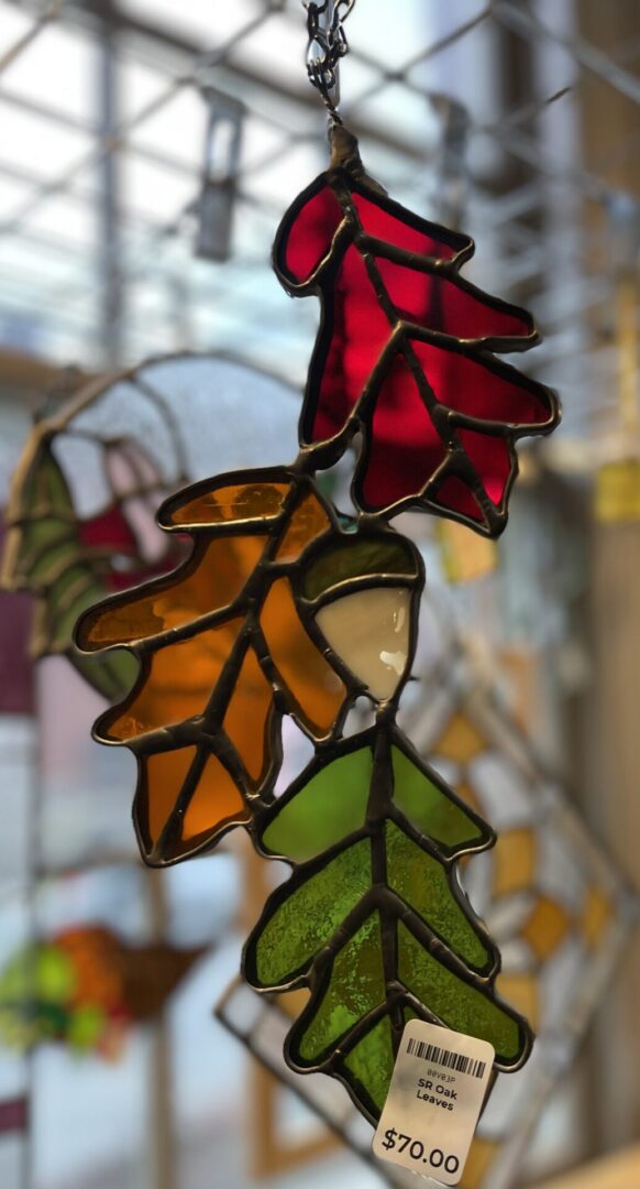 A stained glass leaf hanging from a window.