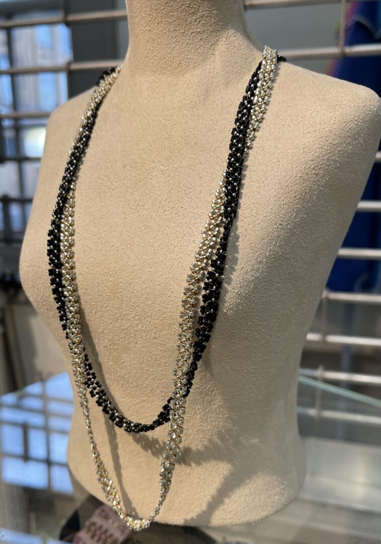 A black and silver necklace on a mannequin mannequin.