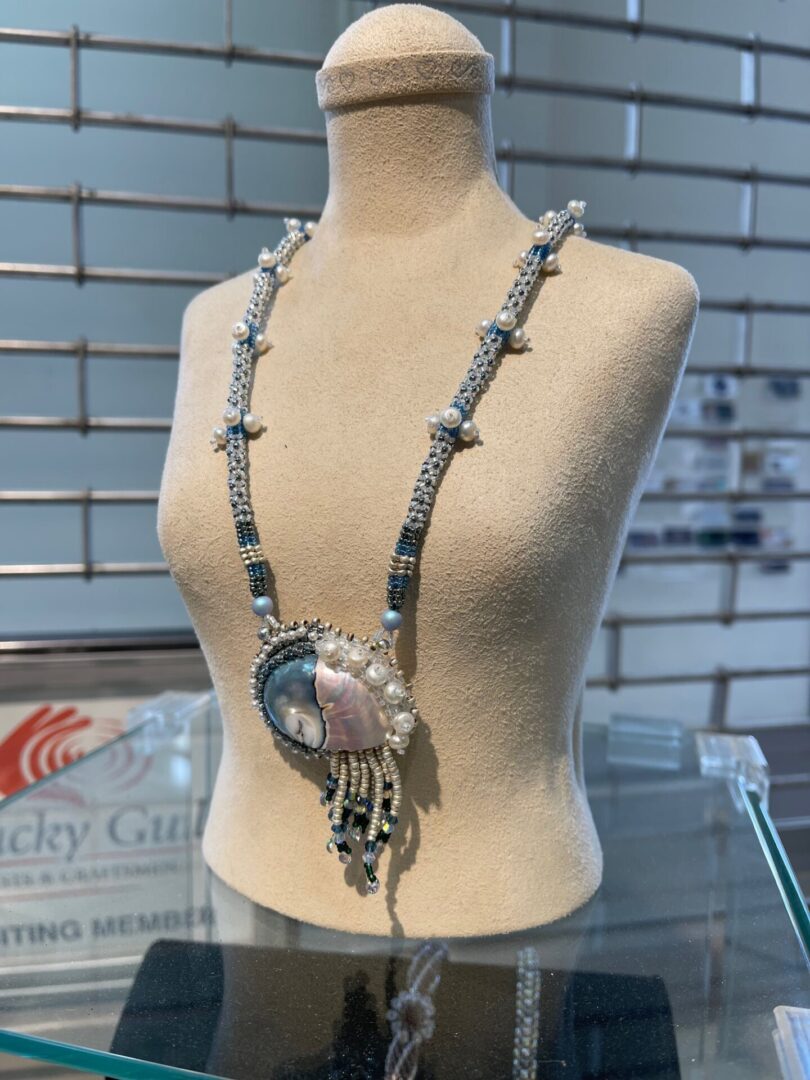 A mannequin with a necklace on display.