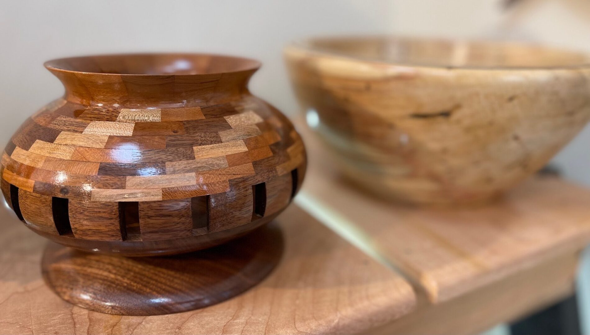 Two wooden bowls on top of a wooden table.