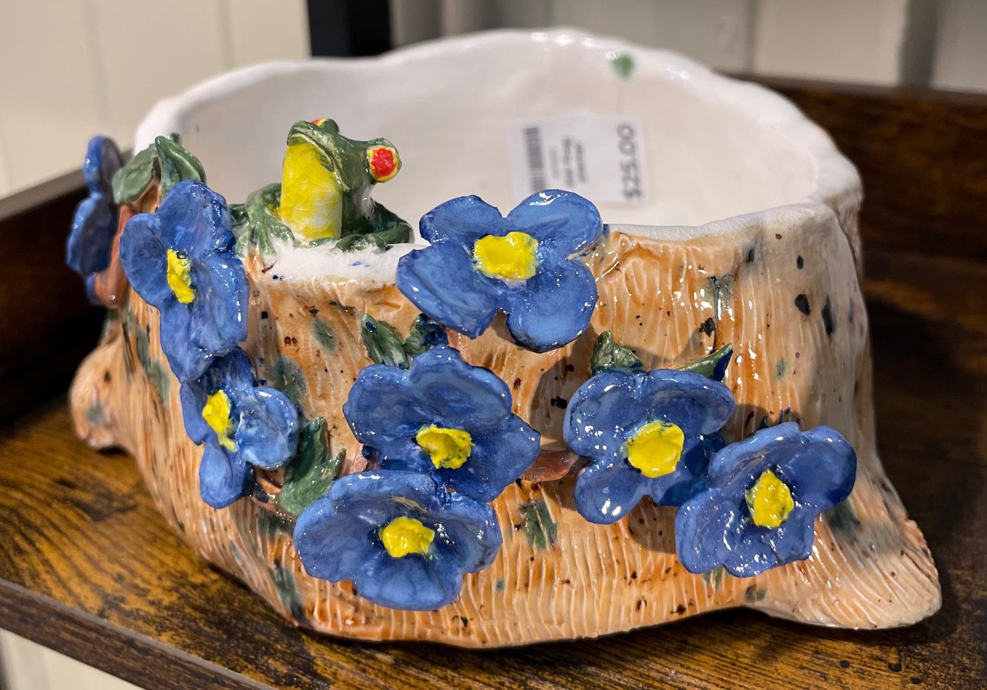 A blue flower pot with a frog on it.