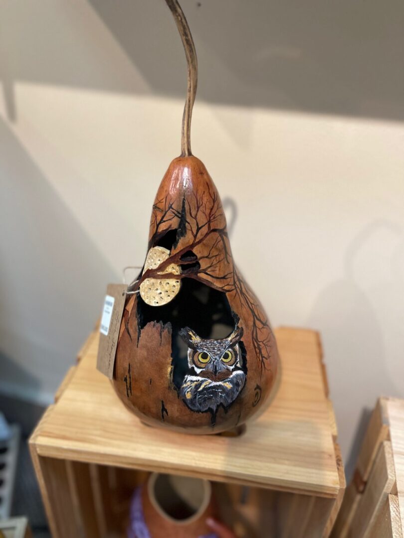 A wooden pear with an owl in it.