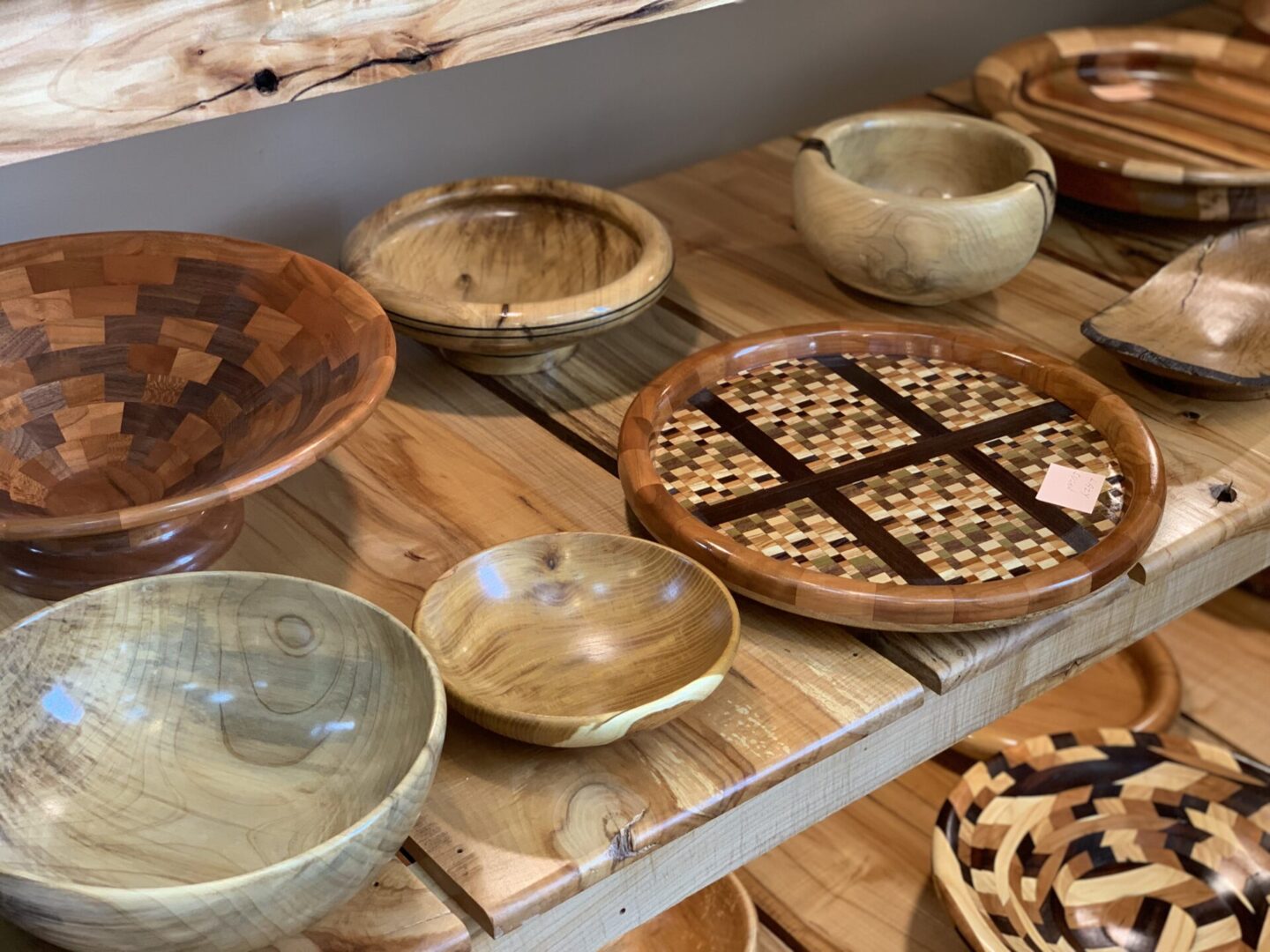 Various wooden bowls are on display in a store.