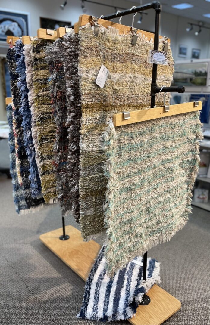 Rugs hanging on a rack in a store.