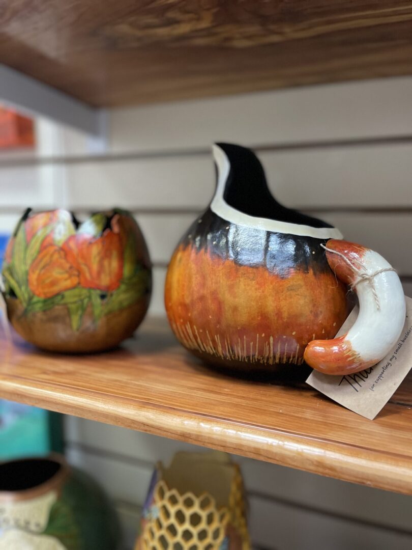 Two ceramic vases on a shelf in a store.