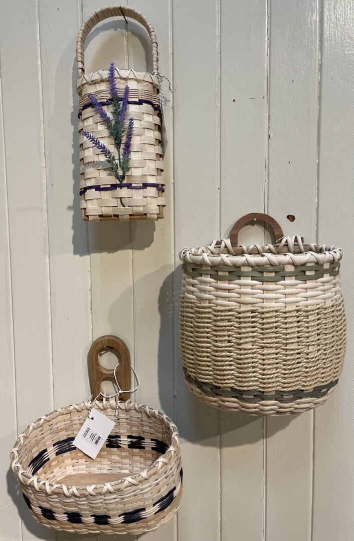 Three wicker baskets hanging on a wall.