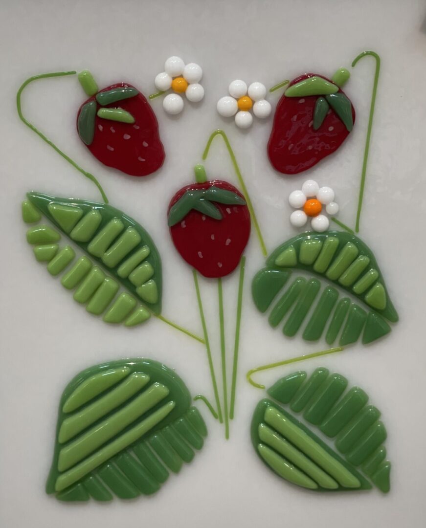 A plate with strawberries, leaves and daisies on it.