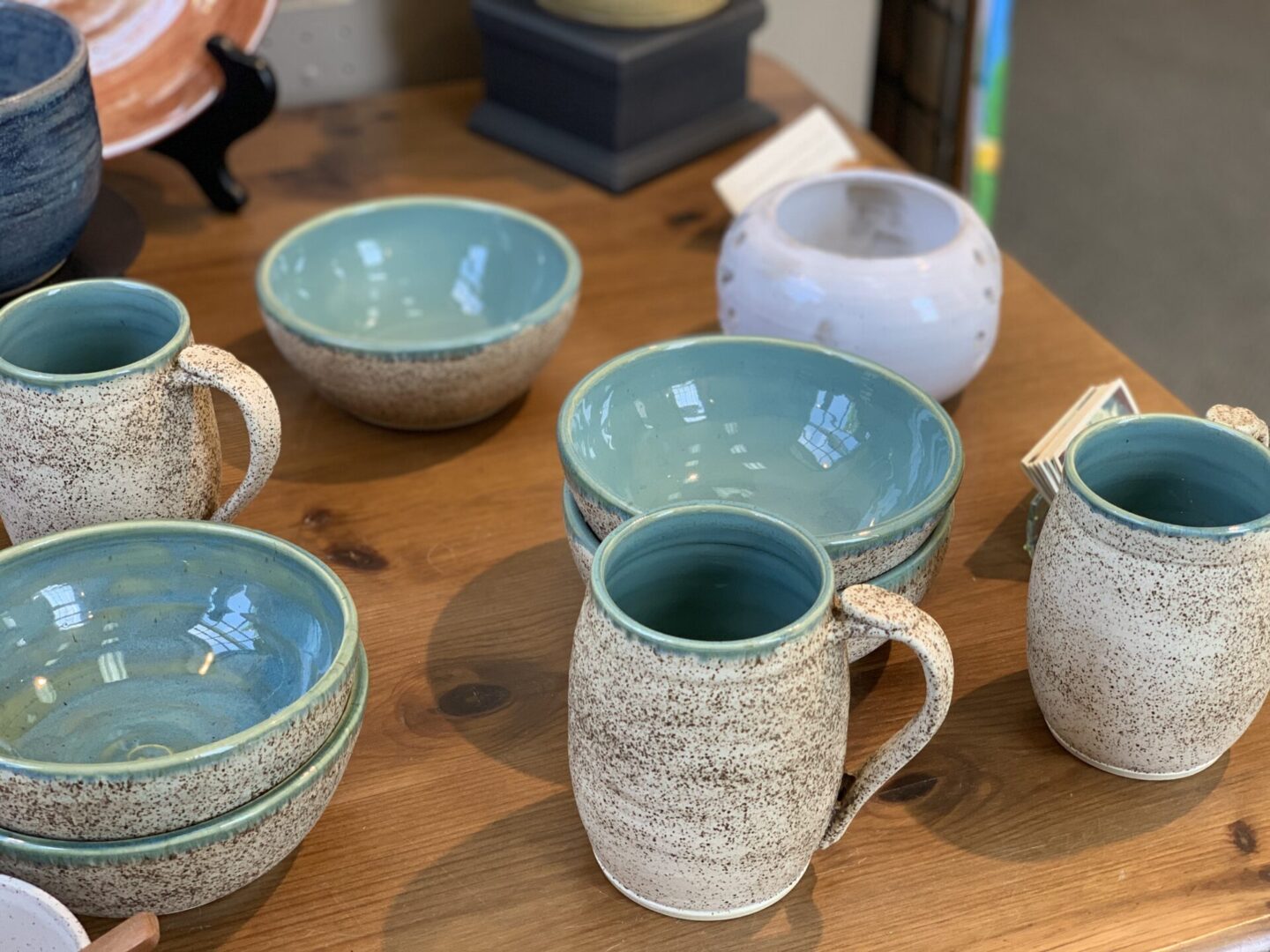 Mugs, bowls and plates on a wooden table.