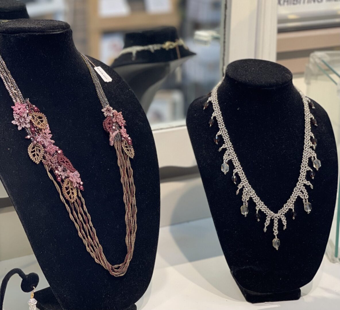 Three necklaces on display in a jewelry store.