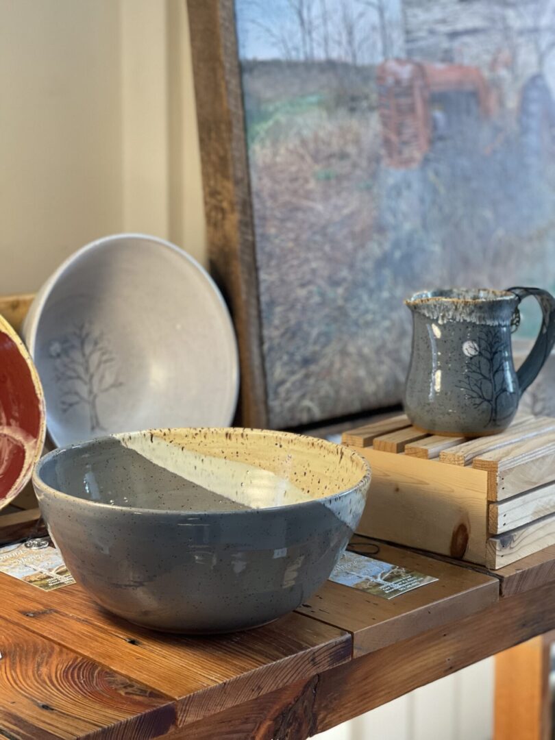 A table with several bowls and mugs on it.