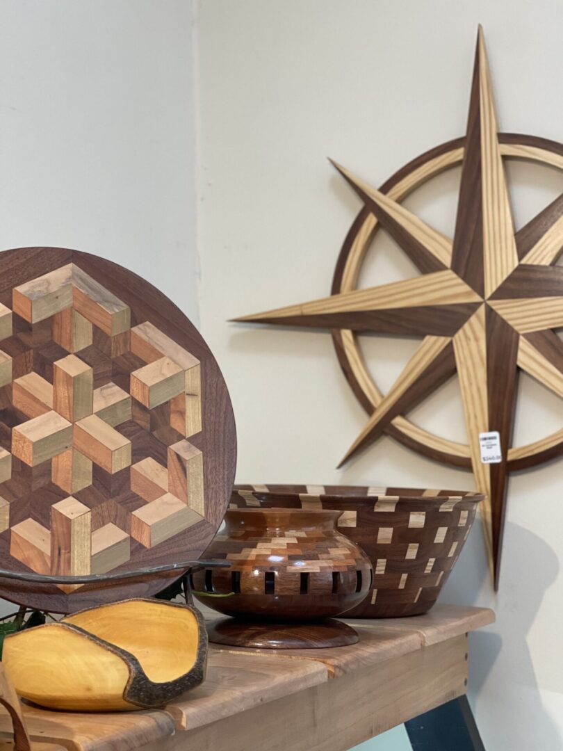 A wooden compass and a wooden bowl on a shelf.
