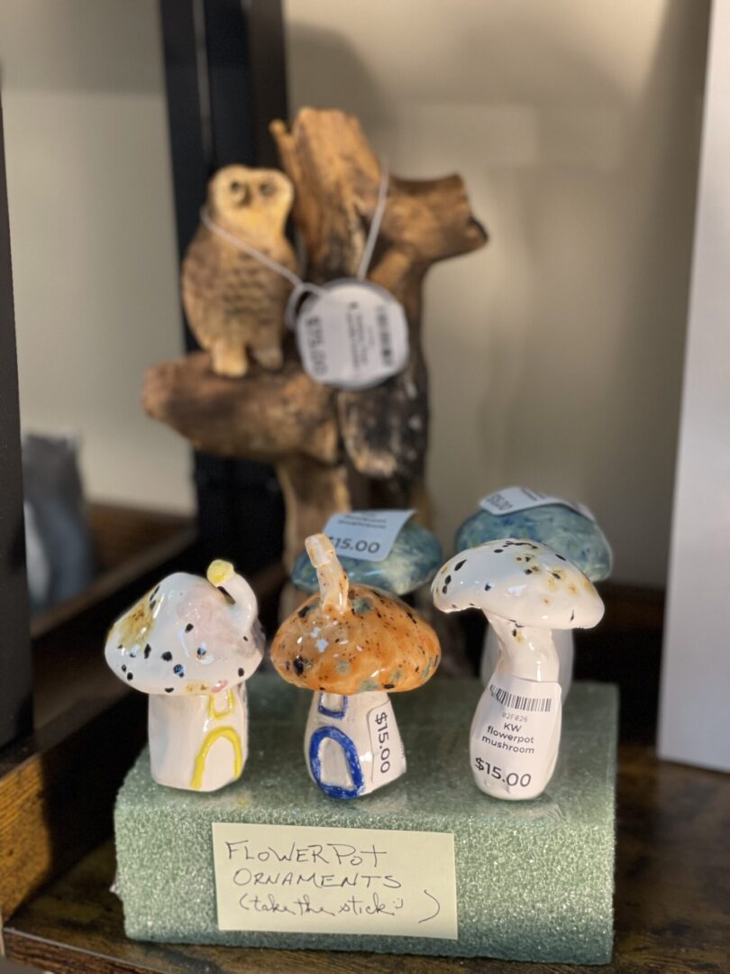 A display of ceramic mushrooms with an owl on top.