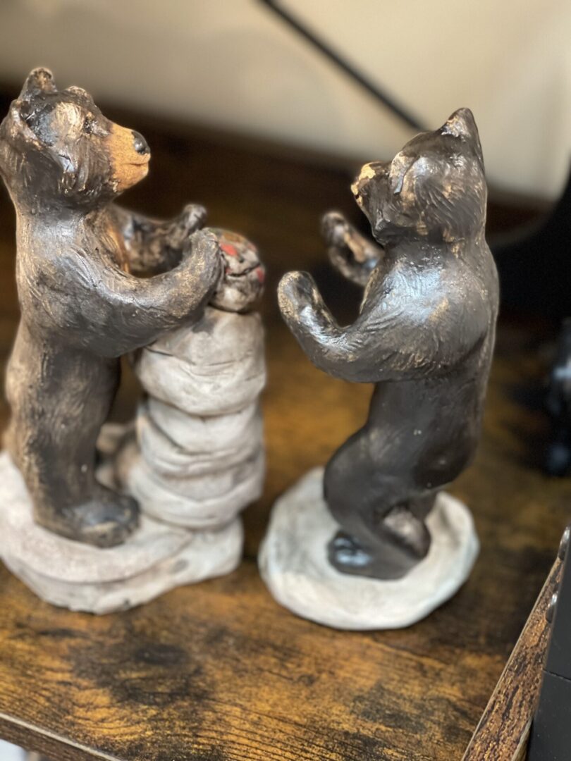 Two black bear figurines on a shelf.
