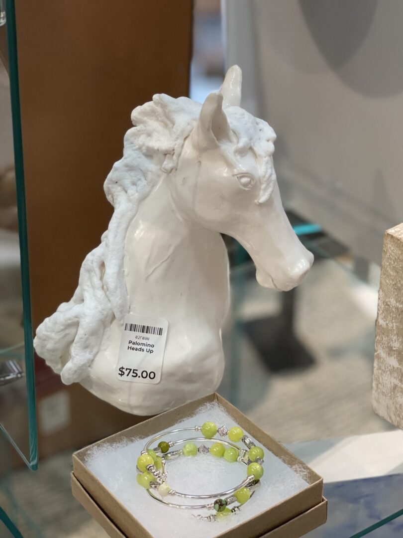A white horse head is on display in a glass case.
