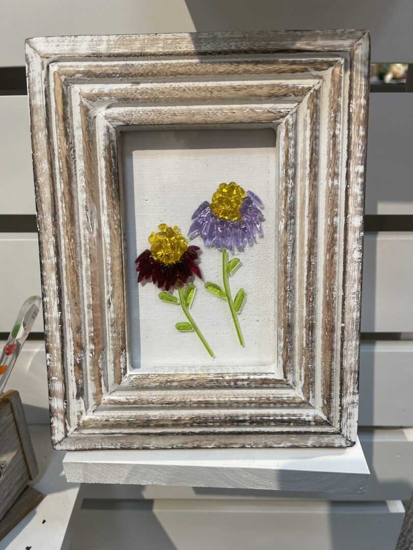 A wooden frame with embroidered flowers on it.
