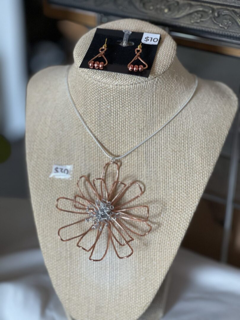 A mannequin with a necklace and earrings.