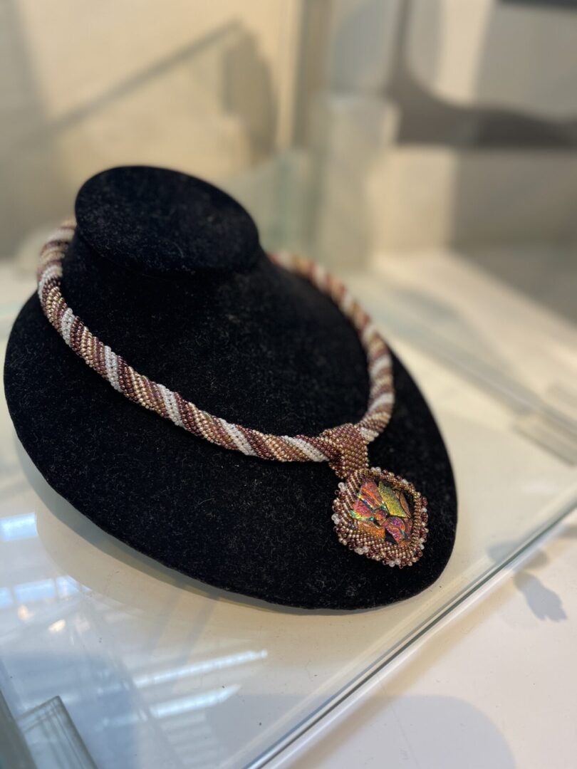 A necklace on display in a display case.