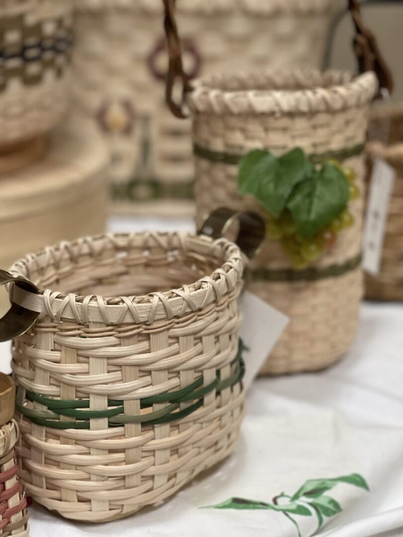 Three baskets on a table with green leaves on them.