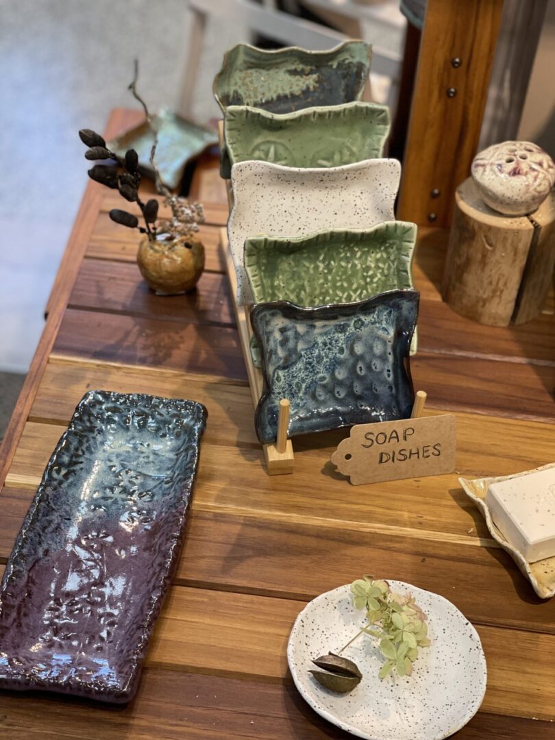 A display of ceramic plates and bowls on a wooden table.
