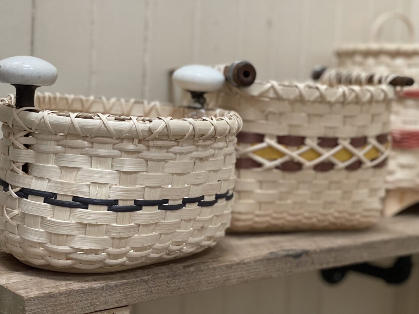 Three baskets are sitting on a shelf next to each other.