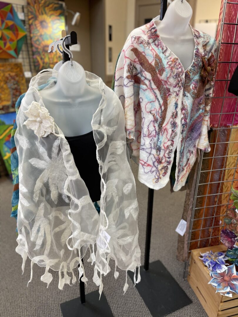 Two shawls on display in a store.