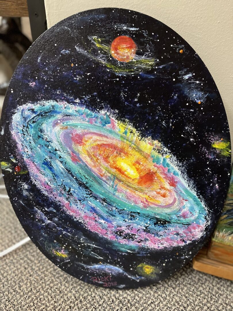 A painting of a galaxy on a table.