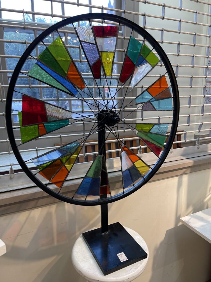 A stained glass wheel on display in a room.