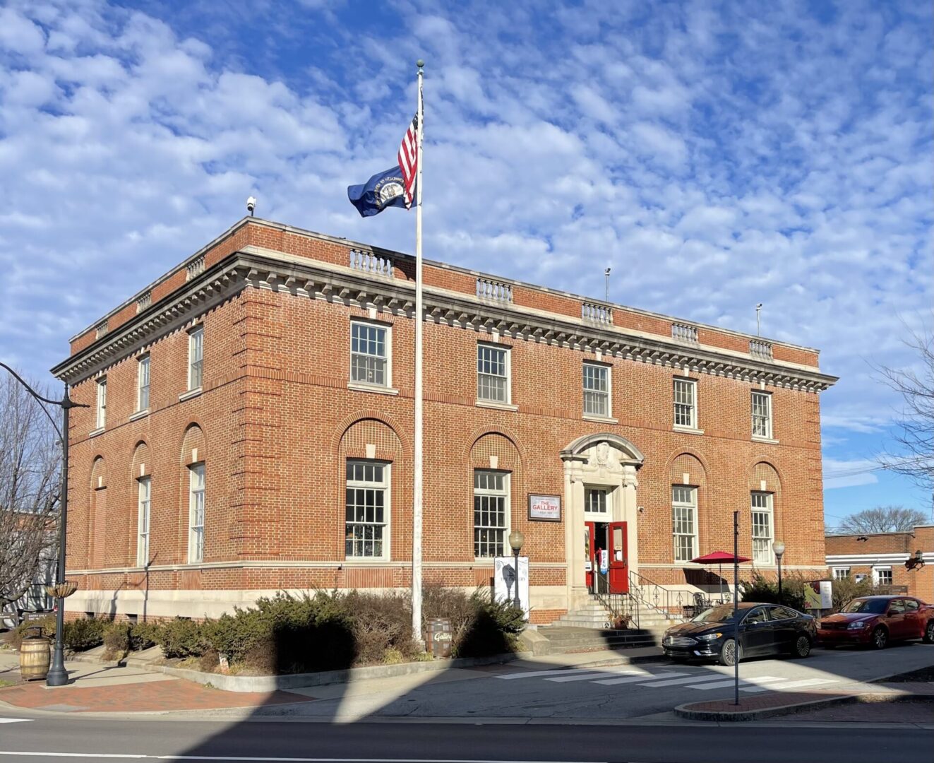 Brick building with a red door and a flag.