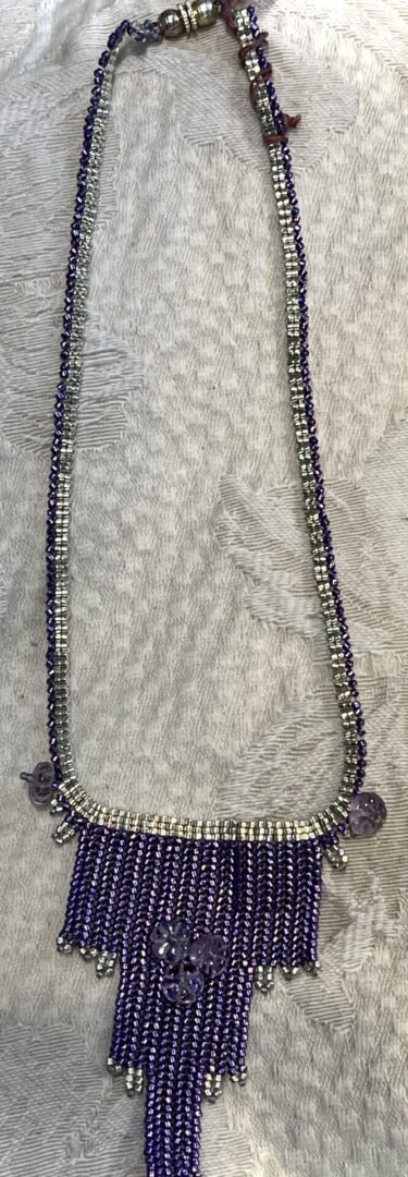 Purple and silver beaded necklace with pendant.