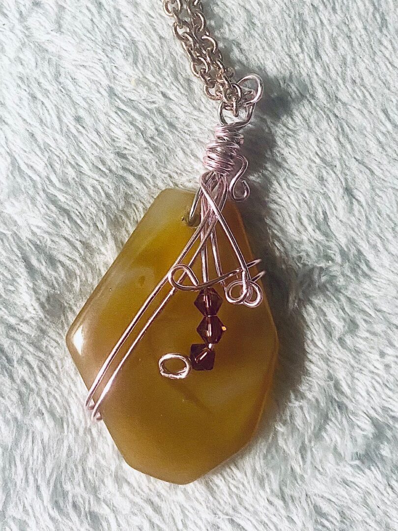 Gold agate pendant on a gold chain.