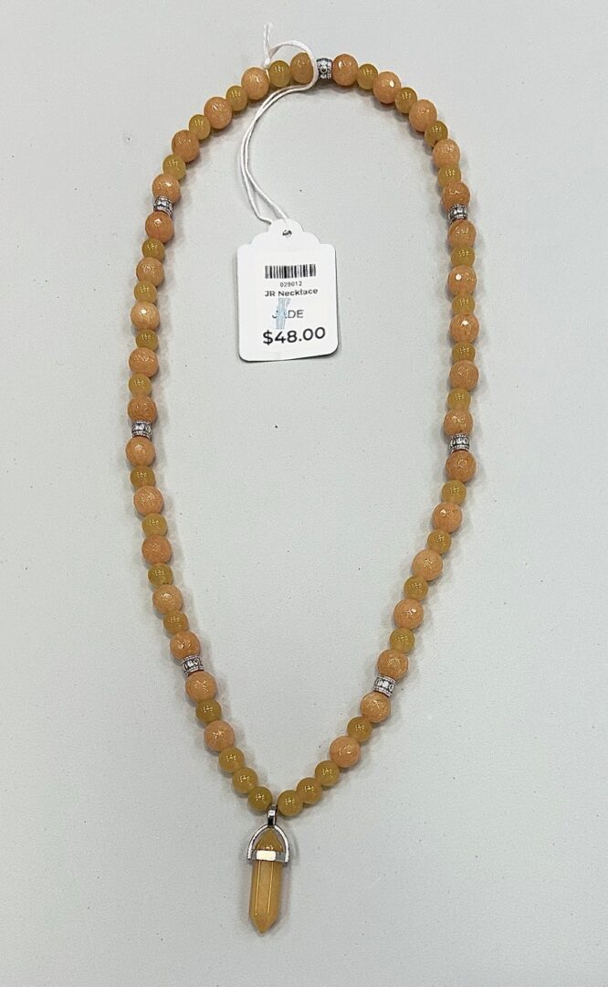 Yellow jade beaded necklace with crystal pendant.